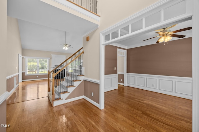 6965 Ogburn Farms Dr, Willow Springs, NC 27592 - stairs with a ceiling fan, wood finished floors, a wainscoted wall, and ornamental molding