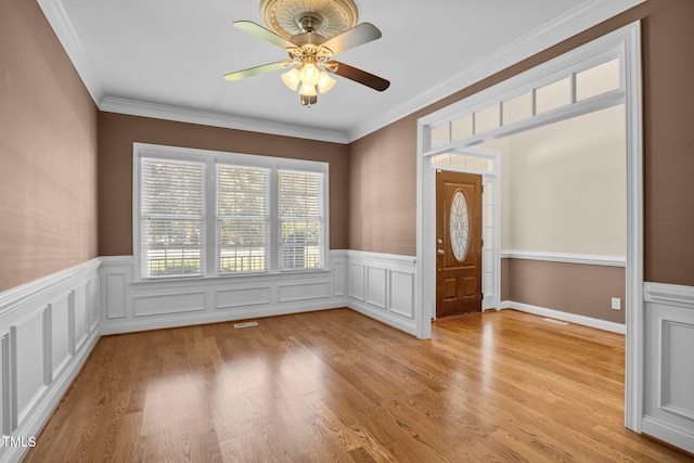 6965 Ogburn Farms Dr, Willow Springs, NC 27592 - spare room featuring a wainscoted wall, a ceiling fan, ornamental molding, and light wood finished floors