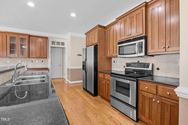 6965 Ogburn Farms Dr, Willow Springs, NC 27592 - kitchen featuring appliances with stainless steel finishes, brown cabinetry, light wood finished floors, crown molding, and recessed lighting