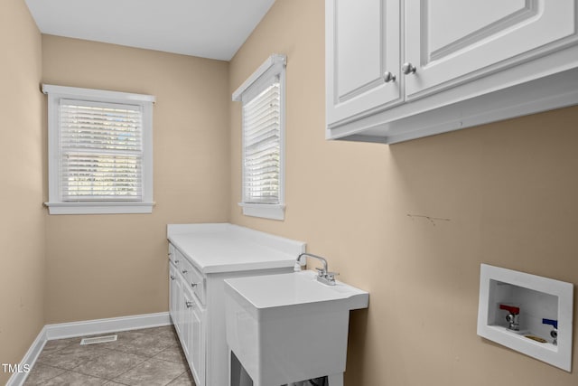 6965 Ogburn Farms Dr, Willow Springs, NC 27592 - washroom featuring washer hookup, cabinet space, healthy amount of natural light, and light tile patterned floors