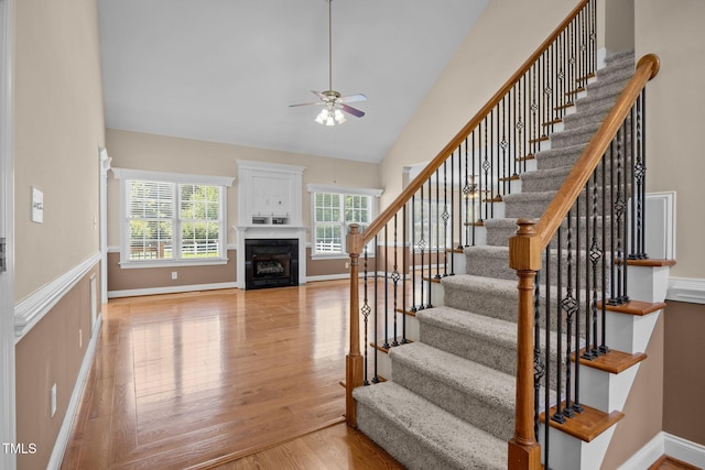 6965 Ogburn Farms Dr, Willow Springs, NC 27592 - stairs with ceiling fan, wood finished floors, a fireplace, and high vaulted ceiling
