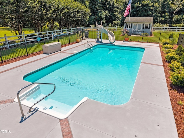 6965 Ogburn Farms Dr, Willow Springs, NC 27592 - view of pool with a water slide, a patio, an outbuilding, and view of scattered trees
