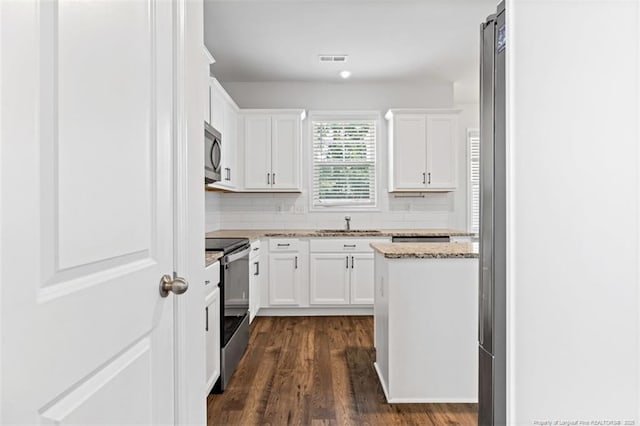 399 Springhaven Dr, Raeford, NC 28376 - kitchen with stainless steel appliances, light stone countertops, dark wood-style flooring, white cabinets, and backsplash