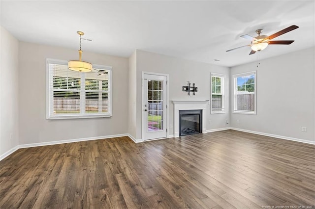 399 Springhaven Dr, Raeford, NC 28376 - unfurnished living room with dark wood-type flooring, a ceiling fan, and a fireplace