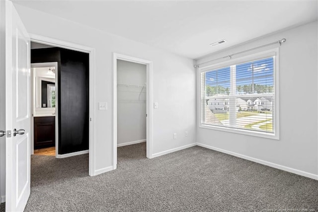 399 Springhaven Dr, Raeford, NC 28376 - unfurnished bedroom featuring carpet flooring, a spacious closet, and a closet