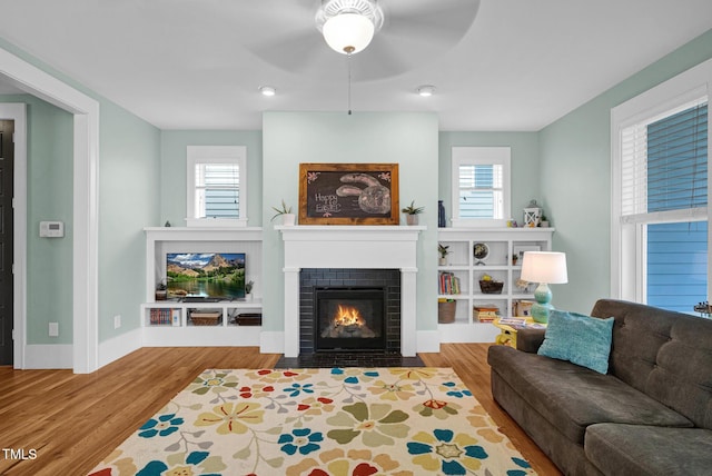 322 Tobacco Farm Way, Chapel Hill, NC 27516 - living area featuring a brick fireplace, ceiling fan, wood finished floors, and plenty of natural light