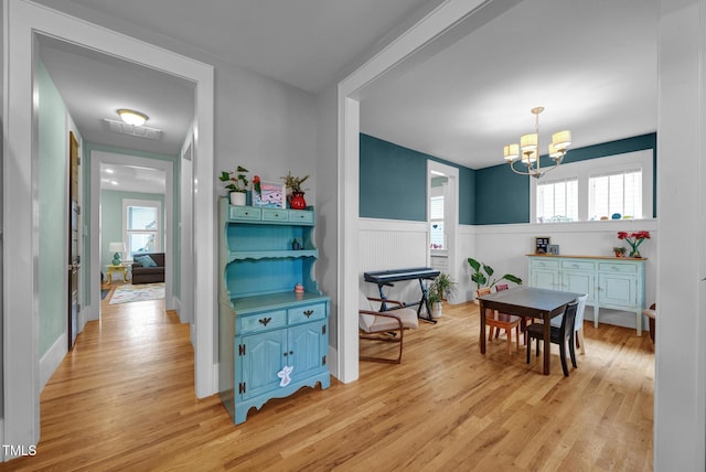 322 Tobacco Farm Way, Chapel Hill, NC 27516 - dining area featuring a chandelier, light wood-style flooring, and a wainscoted wall