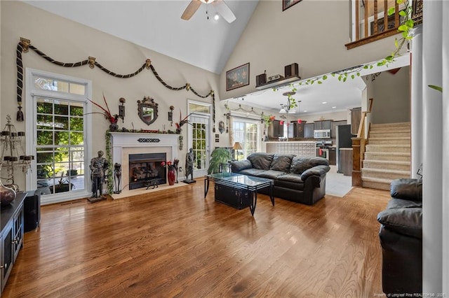115 Race Ct, Godwin, NC 28344 - living room featuring a ceiling fan, healthy amount of natural light, stairs, high vaulted ceiling, and a fireplace