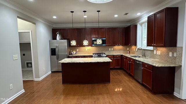 205 Bog Hill Ln, Cary, NC 27519 - kitchen with appliances with stainless steel finishes, dark wood finished floors, a center island, light stone countertops, and ornamental molding