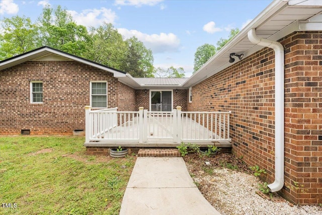 410 W Tenth St, Siler City, NC 27344 - doorway to property with a wooden deck, brick siding, a yard, and crawl space
