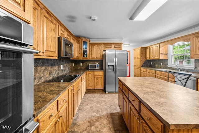 410 W Tenth St, Siler City, NC 27344 - kitchen featuring appliances with stainless steel finishes, decorative backsplash, glass insert cabinets, a center island, and dark countertops