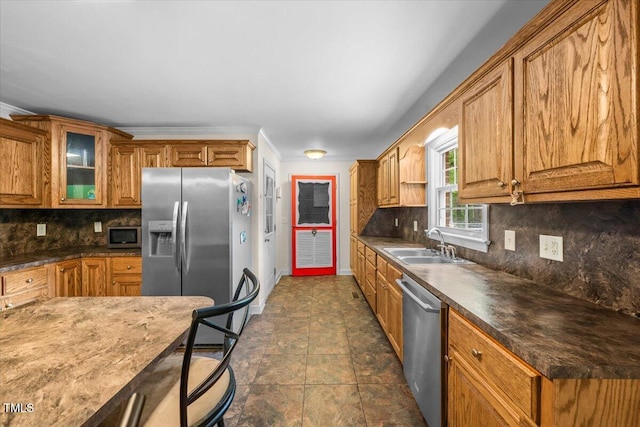 410 W Tenth St, Siler City, NC 27344 - kitchen with appliances with stainless steel finishes, brown cabinetry, tasteful backsplash, and glass insert cabinets