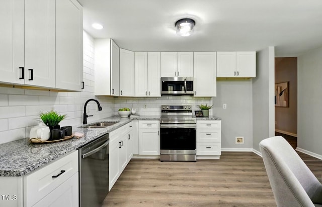 117 S Woodstone Dr, Archer Lodge, NC 27527 - kitchen featuring stainless steel appliances, light wood-type flooring, light stone counters, white cabinetry, and recessed lighting