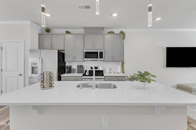 4949 Microcline Trl, Raleigh, NC 27610 - kitchen with appliances with stainless steel finishes, gray cabinets, crown molding, tasteful backsplash, and a center island with sink