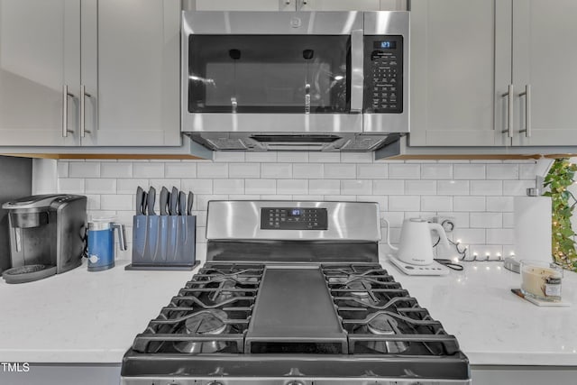 4949 Microcline Trl, Raleigh, NC 27610 - kitchen featuring stainless steel appliances, decorative backsplash, and light stone counters