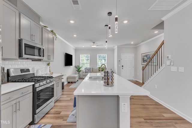 4949 Microcline Trl, Raleigh, NC 27610 - kitchen featuring stainless steel appliances, crown molding, gray cabinetry, a ceiling fan, and open floor plan