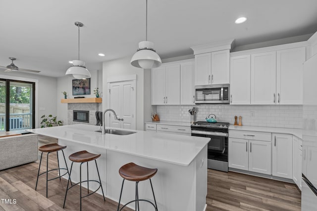 409 S Tunstall Ave, Apex, NC 27502 - kitchen featuring appliances with stainless steel finishes, open floor plan, recessed lighting, white cabinets, and a breakfast bar