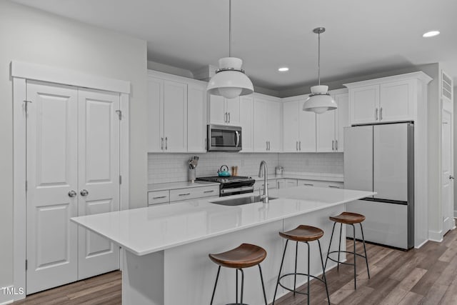 409 S Tunstall Ave, Apex, NC 27502 - kitchen with freestanding refrigerator, stainless steel microwave, dark wood-style flooring, recessed lighting, and white cabinets