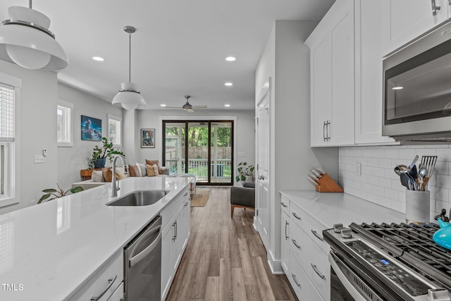 409 S Tunstall Ave, Apex, NC 27502 - kitchen with appliances with stainless steel finishes, open floor plan, recessed lighting, tasteful backsplash, and wood finished floors