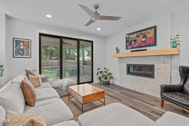 409 S Tunstall Ave, Apex, NC 27502 - living area featuring wood finished floors, a stone fireplace, a ceiling fan, and recessed lighting