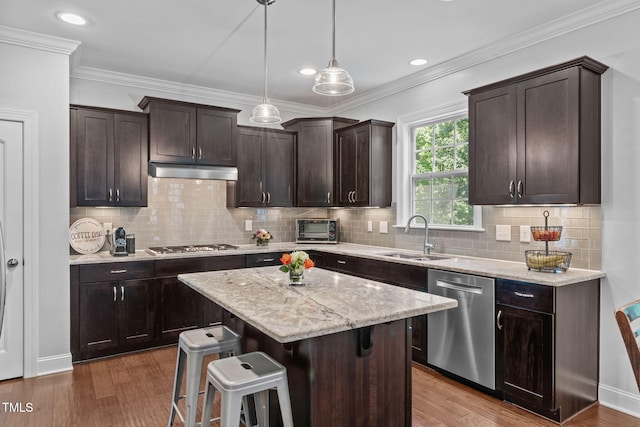 2716 Lake Waccamaw Trl, Apex, NC 27502 - kitchen featuring stainless steel appliances, dark brown cabinets, under cabinet range hood, light stone counters, and ornamental molding