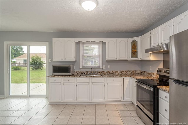 2408 Crabtree Ct, Fayetteville, NC 28304 - kitchen featuring appliances with stainless steel finishes, under cabinet range hood, light stone countertops, white cabinets, and a textured ceiling