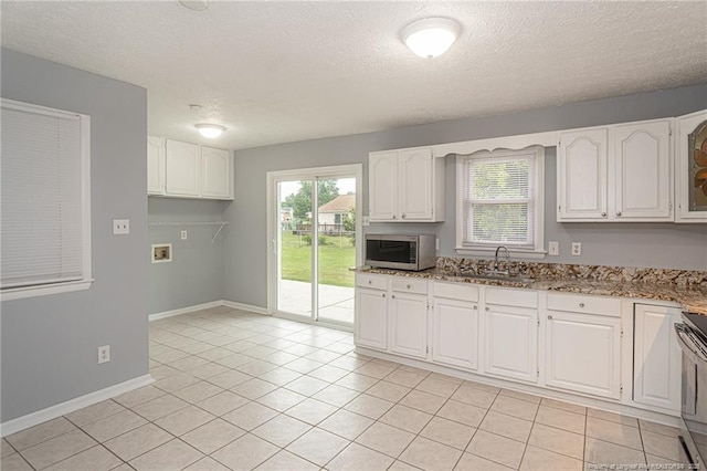 2408 Crabtree Ct, Fayetteville, NC 28304 - kitchen featuring stainless steel appliances, white cabinetry, plenty of natural light, light stone counters, and a textured ceiling
