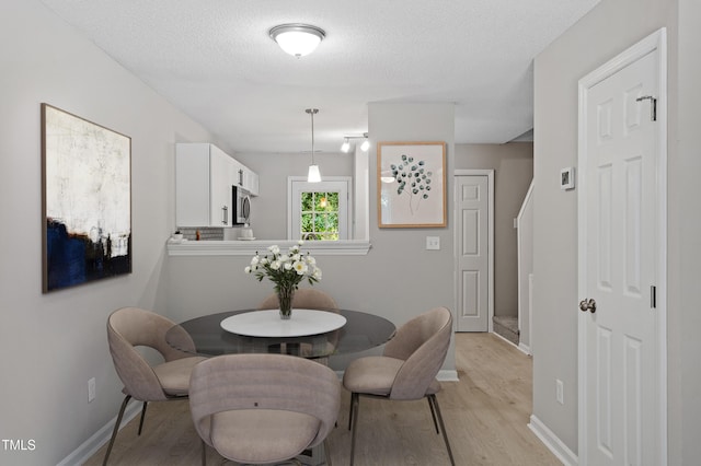 4242 Kaplan Dr, Raleigh, NC 27606 - dining space featuring light wood-style floors and a textured ceiling