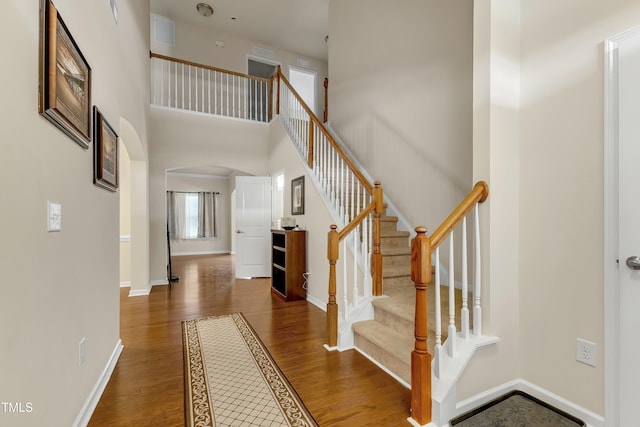 316 Vintage Holly Dr, Durham, NC 27703 - entrance foyer featuring arched walkways, wood finished floors, stairs, and a towering ceiling