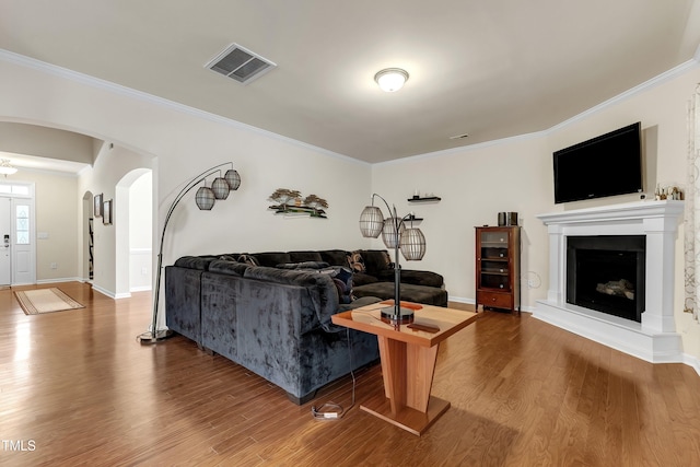 316 Vintage Holly Dr, Durham, NC 27703 - living room featuring arched walkways, ornamental molding, wood finished floors, and a fireplace with raised hearth