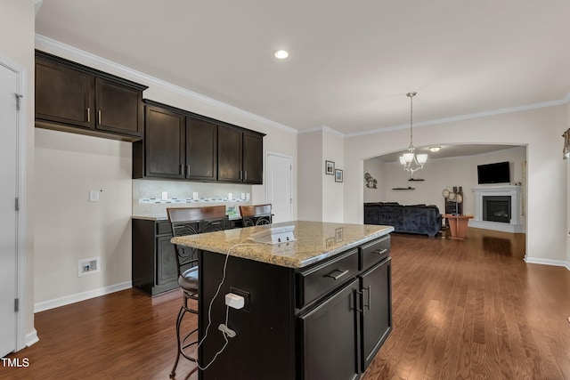 316 Vintage Holly Dr, Durham, NC 27703 - kitchen with open floor plan, light stone countertops, dark wood-style flooring, decorative backsplash, and a center island