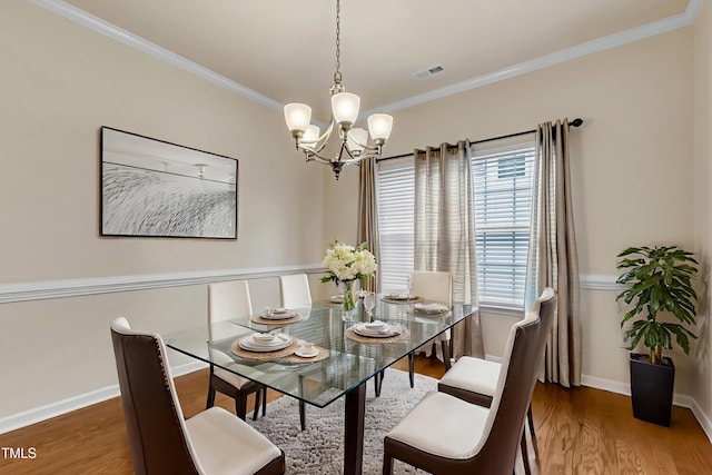 316 Vintage Holly Dr, Durham, NC 27703 - dining area with a chandelier, wood finished floors, and crown molding