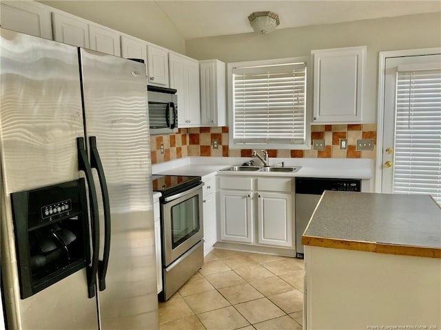 101 Horace Ct, Raeford, NC 28376 - kitchen featuring appliances with stainless steel finishes, white cabinets, decorative backsplash, lofted ceiling, and light tile patterned floors