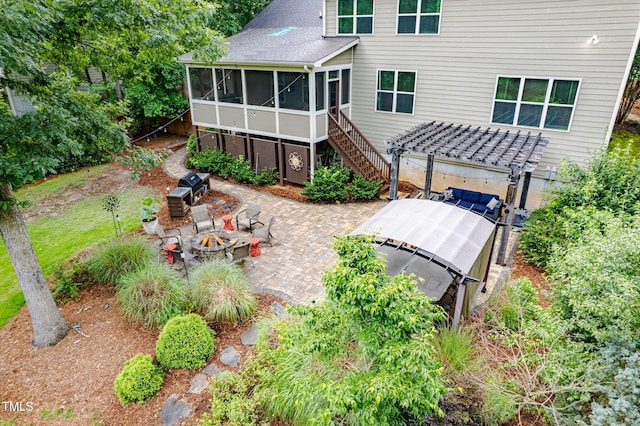 218 Inwood Forest Dr, Raleigh, NC 27603 - rear view of house with a sunroom, an outdoor fire pit, a patio area, stairway, and a hot tub