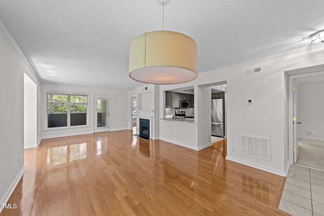1010 Nicholwood Dr Unit 301, Raleigh, NC 27605 - unfurnished living room featuring light wood-style flooring, crown molding, and a fireplace with flush hearth