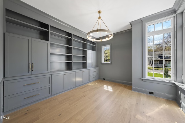 625 Glascock St, Raleigh, NC 27604 - unfurnished dining area with crown molding, light wood-style flooring, and a chandelier