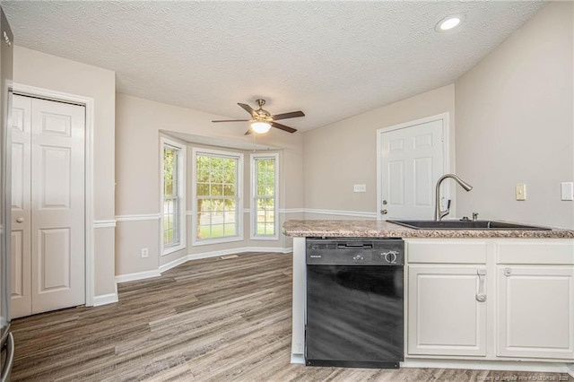 337 Buckeye Dr, Raeford, NC 28376 - kitchen with black dishwasher, ceiling fan, light wood-style floors, white cabinets, and light countertops