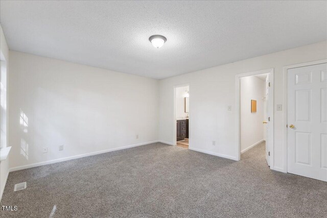 1209 Waterford Green Dr, Apex, NC 27502 - unfurnished bedroom with carpet floors, a textured ceiling, and connected bathroom