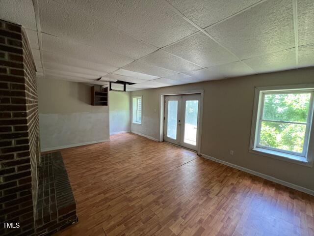 162 Black Horse Ln, Kittrell, NC 27544 - unfurnished living room with wood finished floors, a drop ceiling, and french doors