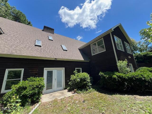 162 Black Horse Ln, Kittrell, NC 27544 - rear view of house with french doors, a chimney, and roof with shingles
