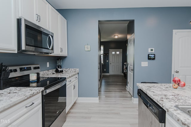 2586 Lacey Holt Rd, Graham, NC 27253 - kitchen with stainless steel appliances, white cabinets, light stone counters, and light wood-style flooring