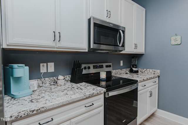 2586 Lacey Holt Rd, Graham, NC 27253 - kitchen with stainless steel appliances, light stone counters, and white cabinets