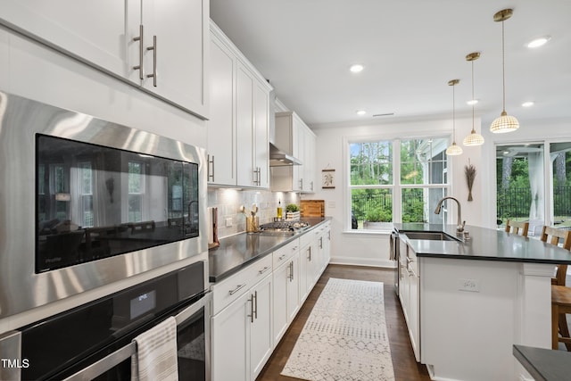 2013 Latham Oaks Ave, Wake Forest, NC 27587 - kitchen featuring appliances with stainless steel finishes, dark countertops, dark wood-style flooring, a center island with sink, and recessed lighting