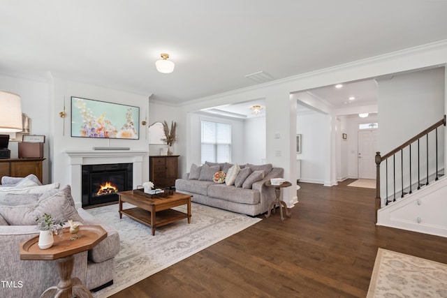 2013 Latham Oaks Ave, Wake Forest, NC 27587 - living area with crown molding, dark wood finished floors, a glass covered fireplace, and stairway