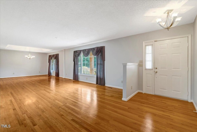 1379 Dr Martin Luther King Jr Blvd, Warrenton, NC 27589 - foyer featuring a chandelier, light wood-style floors, healthy amount of natural light, and a textured ceiling