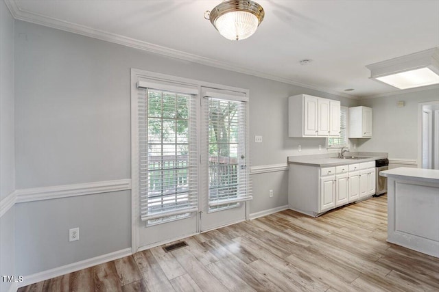 2474 Sumter Dr, Garner, NC 27529 - kitchen with light wood-style flooring, light countertops, white cabinetry, ornamental molding, and stainless steel dishwasher