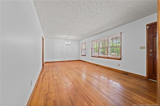 395 N Gaines St, Southern Pines, NC 28387 - spare room with a chandelier, light wood-type flooring, and a textured ceiling