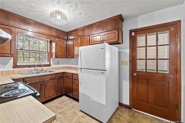 395 N Gaines St, Southern Pines, NC 28387 - kitchen featuring freestanding refrigerator, light countertops, black range with electric cooktop, a textured ceiling, and brown cabinets