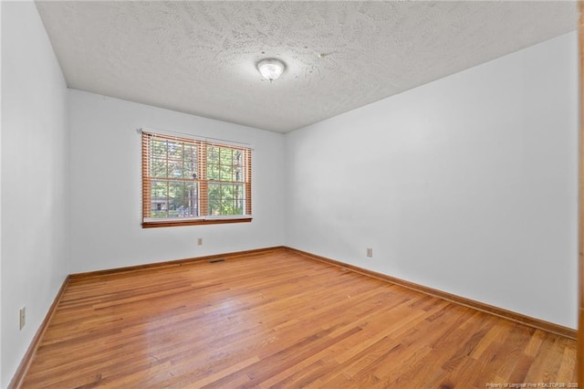 395 N Gaines St, Southern Pines, NC 28387 - empty room with wood finished floors and a textured ceiling
