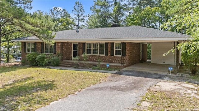 395 N Gaines St, Southern Pines, NC 28387 - single story home with asphalt driveway, brick siding, a front yard, an attached carport, and a chimney
